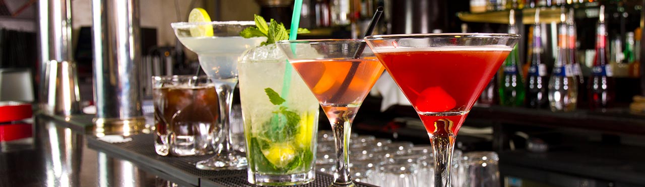 Cocktails staan klaar om geserveerd te worden op een schoongemaakte bar in een café.