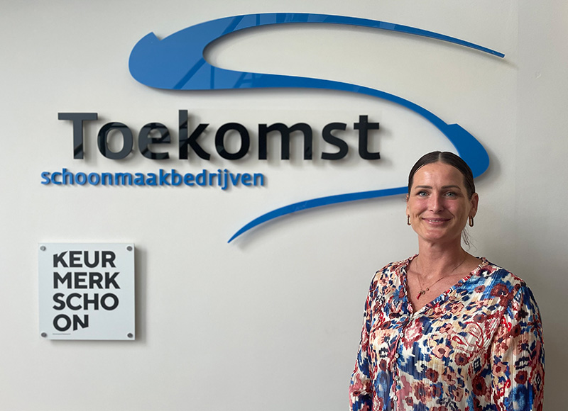 Judith Smulders à côté du logo de Toekomst Schoonmaakbedrijven